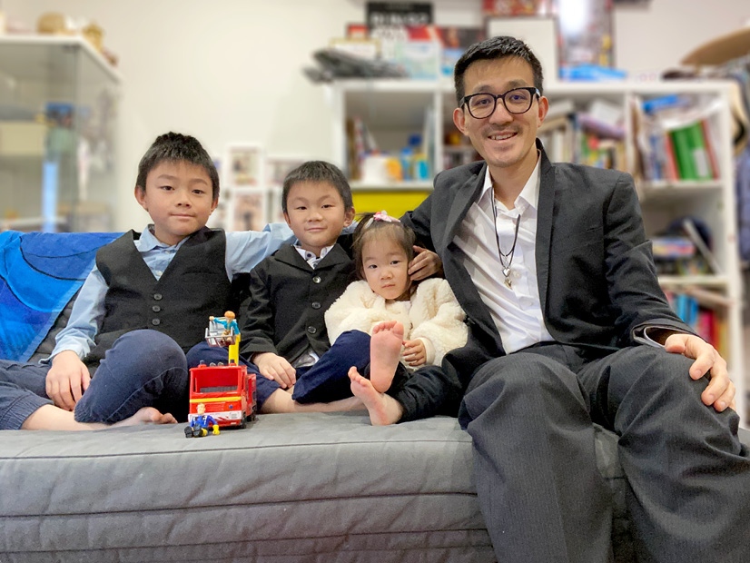 Sam Chew and his three children are sitting in their loungeroom.